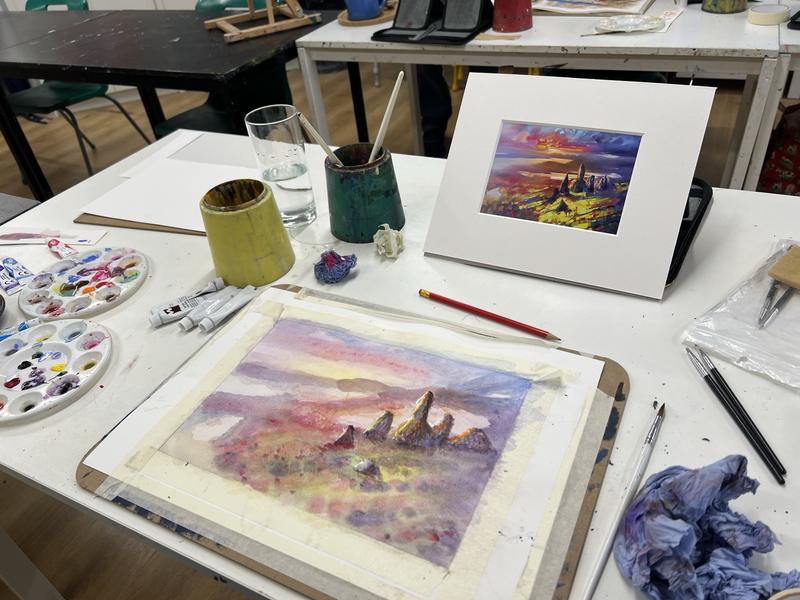 Watercolour landscapes in progress on a Friday morning studio table, with palettes and brushes