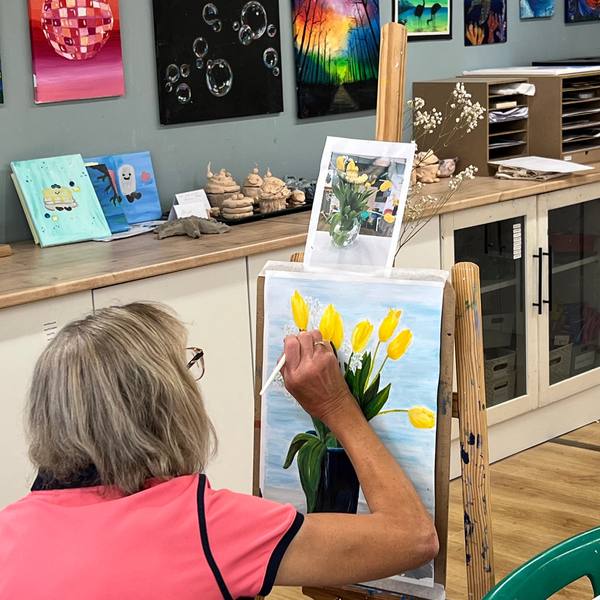 A student painting at an easel in the studio