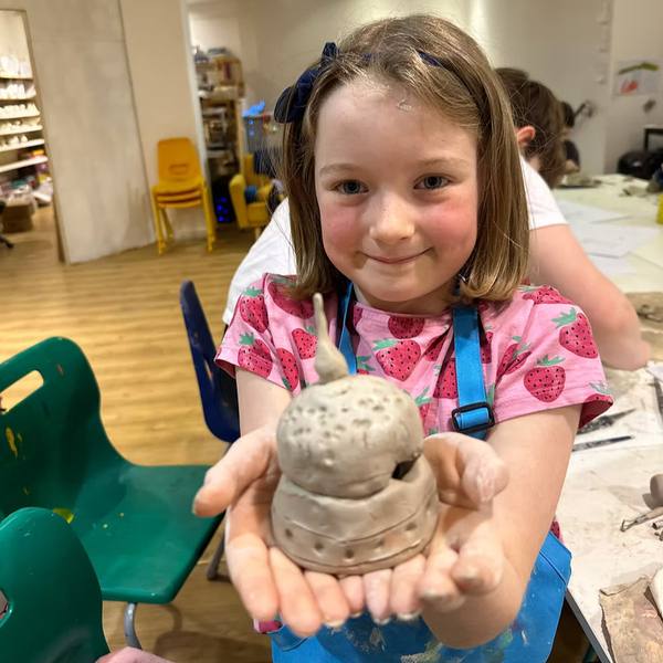 A child holding a clay creation