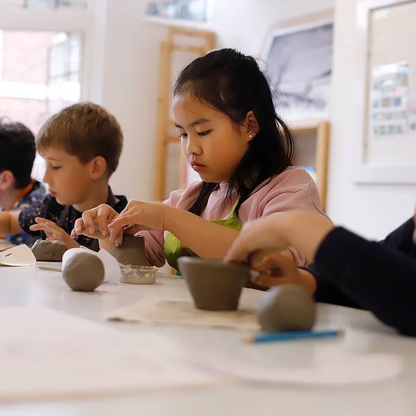 Children making clay pots together