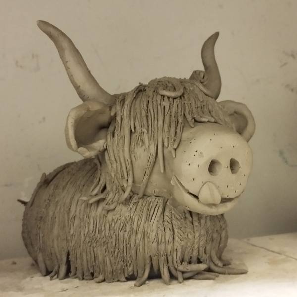 A shaggy clay Highland Cow sculpture made in a workshop